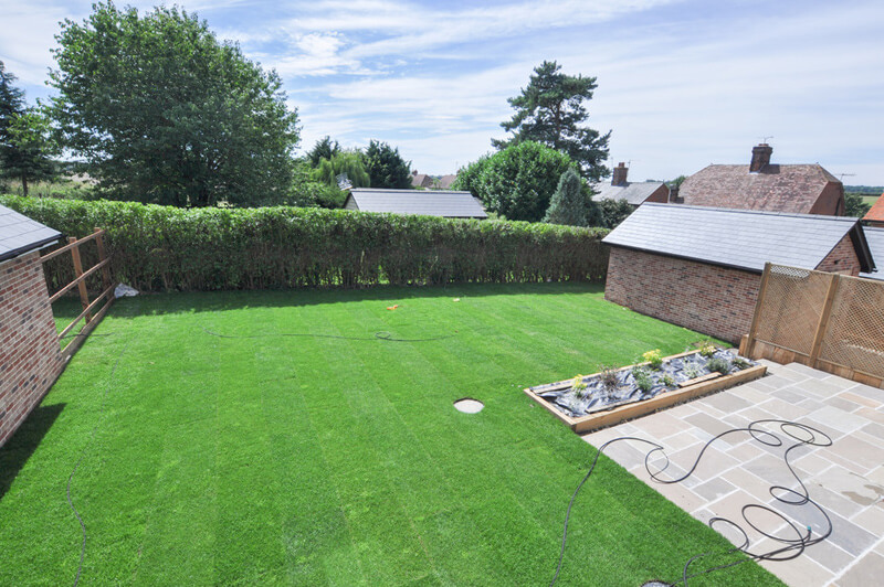 Large back garden with freshly laid grass and patio area.