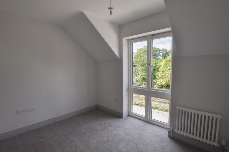 Close up of large bedroom window overlooking trees.