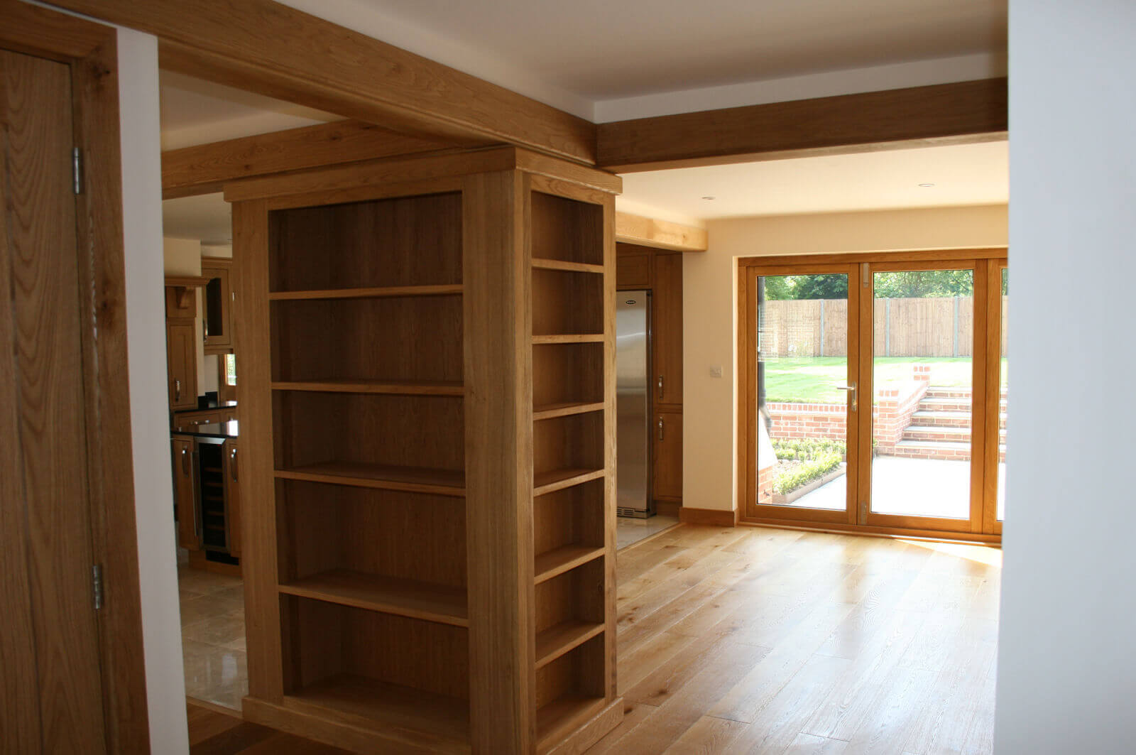 Close up of built-in shelving unit upon which open plan living area and kitchen is centered.