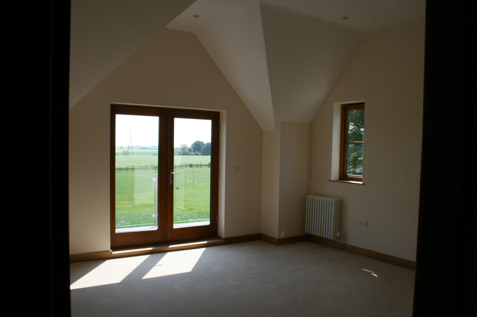 Bright bedrrom with window overlooking countryside to the rear.
