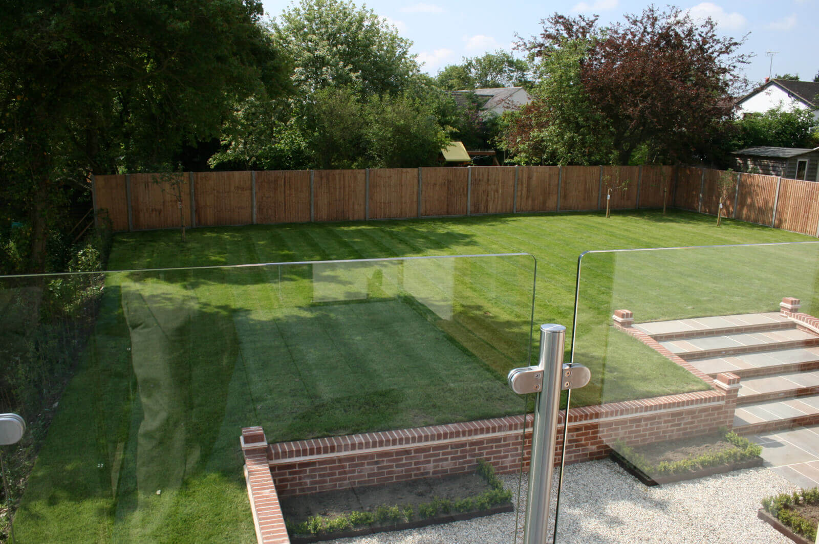 View of garden from balcony with glass surround.