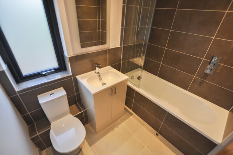 Bathroom with white suite and grey slate tiles.