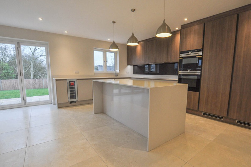 Premium kitchen with centre table and three lights hanging down above the table.