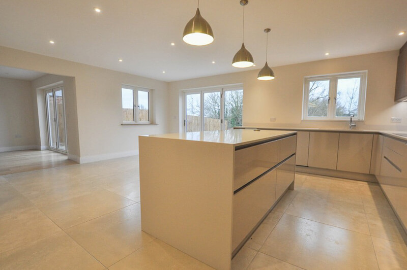 Premium kitchen with centre table and three lights hanging down above the table.