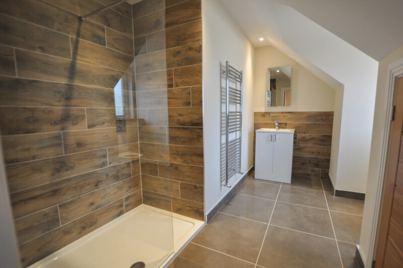 Premium bathroom with shower and large tiled flooring.
