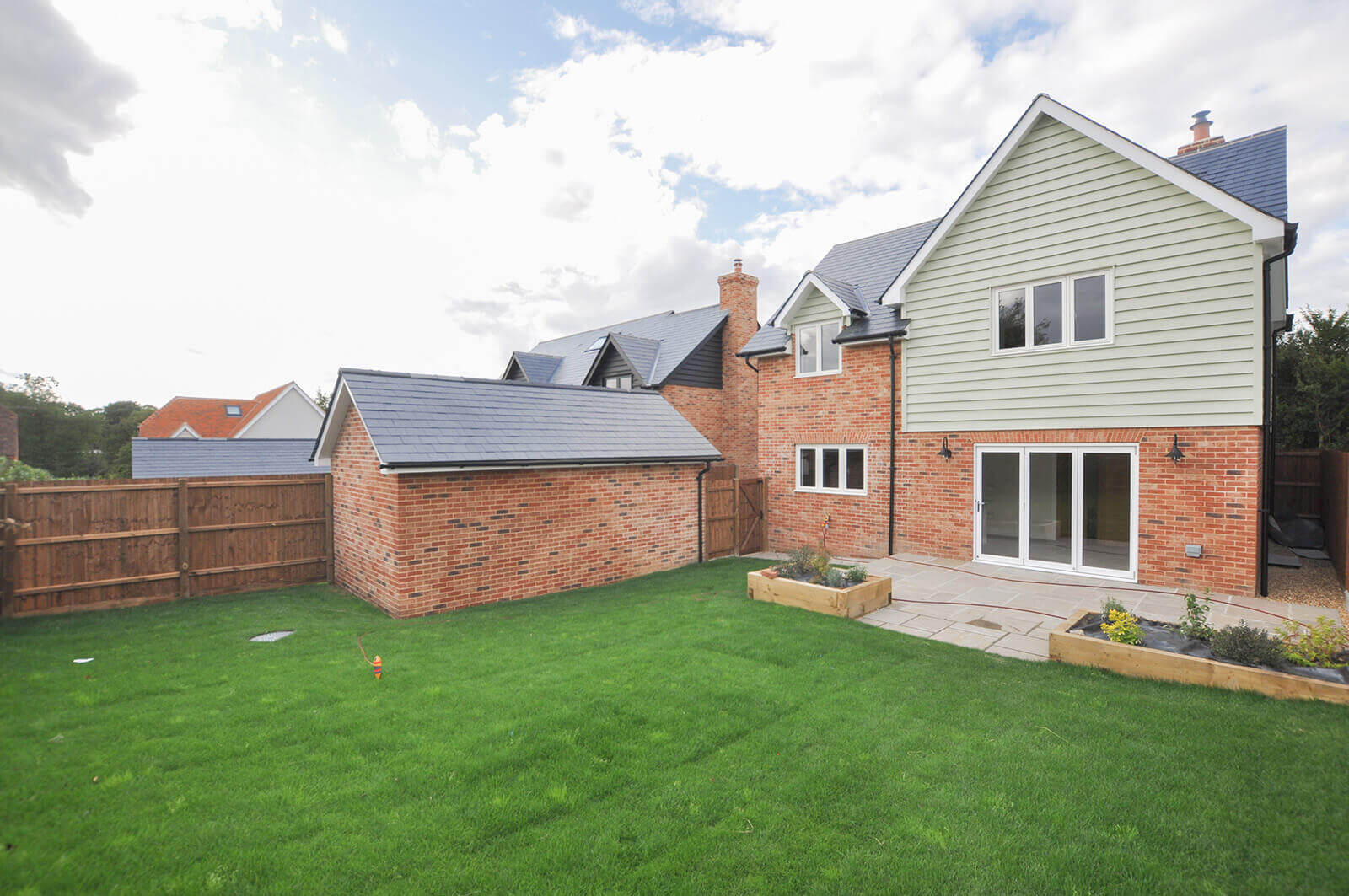 Rear view of house with large garden and patio area.