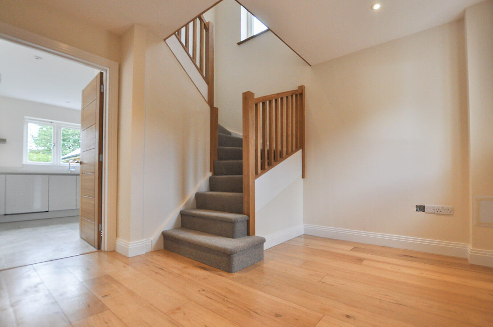 Downstairs hallway with hard wood floor and staircase.