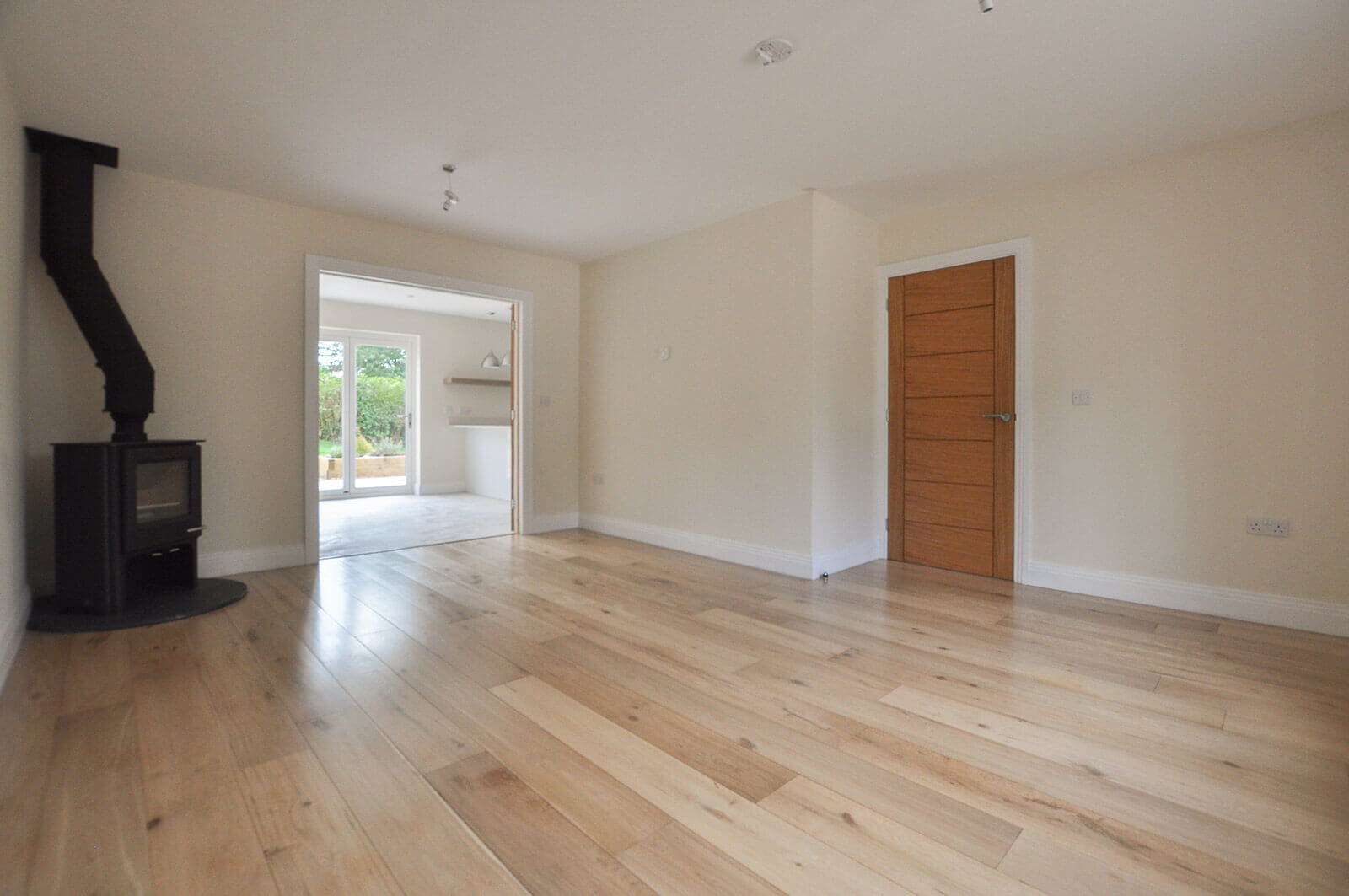 Large downstairs room with fireplace and exposed flue.