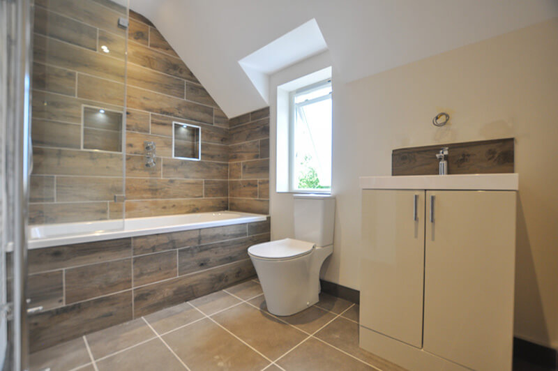 Premium top floor bathroom with white suite, tiled floor and wall.