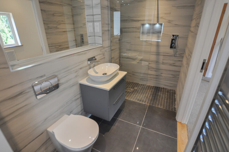 Premium bathroom with white and grey suite, tiled floor and wall.