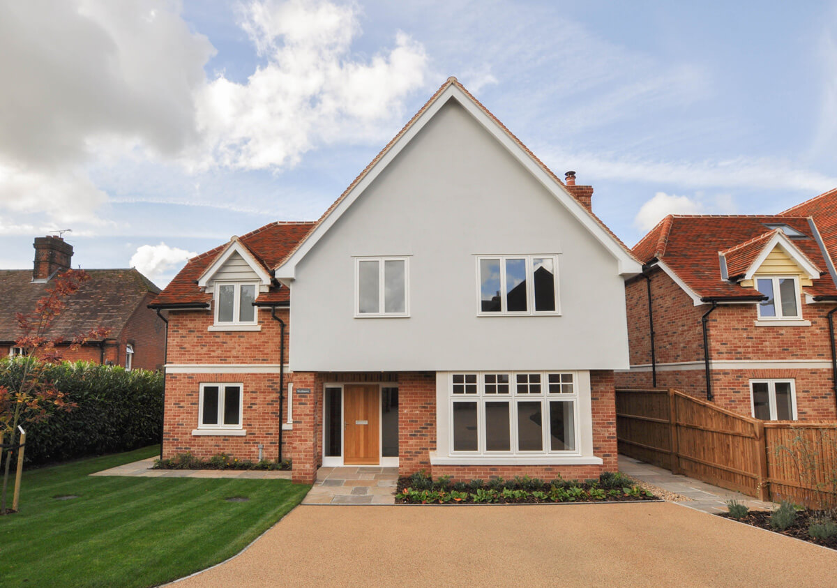 Front view of Wedmore detached house, showing driveway and front garden leading to it.