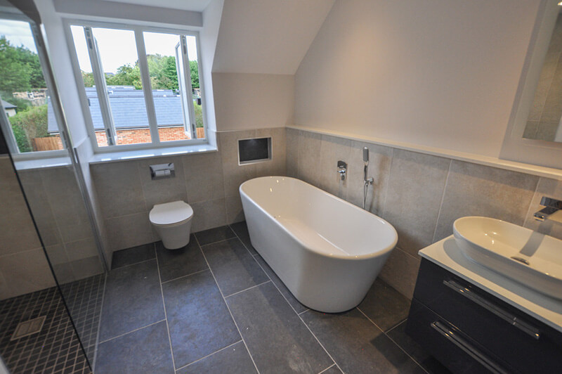 Top floor bathroom with white suite, tiled floors, shower and bath.